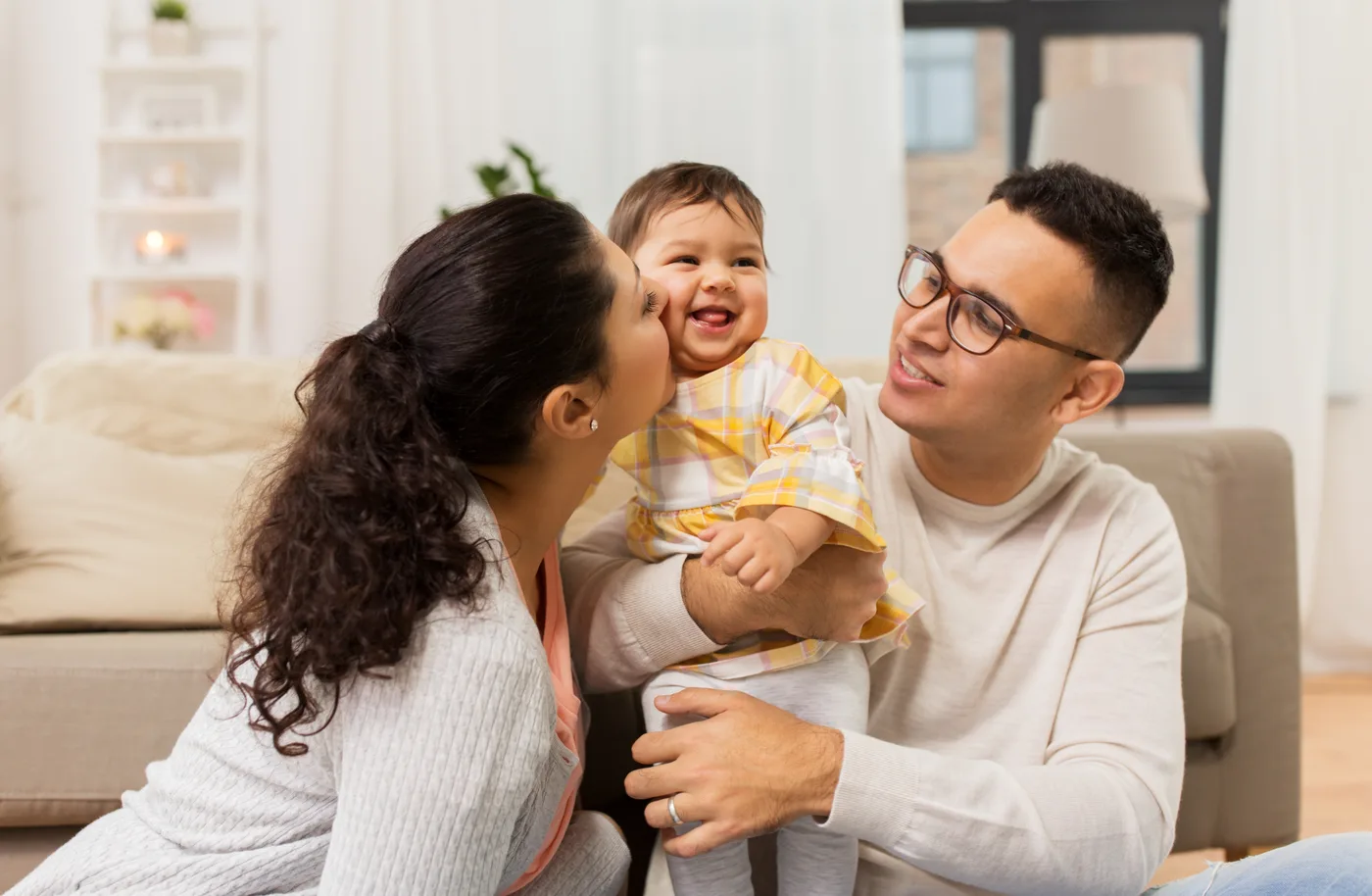 Familia feliz jugando con su bebé en casa